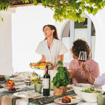 Tavola apparecchiata con vini Doppio Passo e piatti tipici italiani.