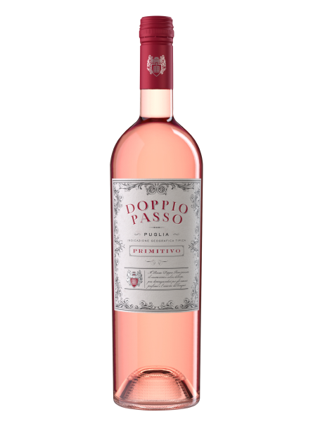 La bottiglia di vino Doppio Passo Primitivo presenta un colore rosa tenue e un'etichetta decorativa che ne sottolinea l'origine pugliese.